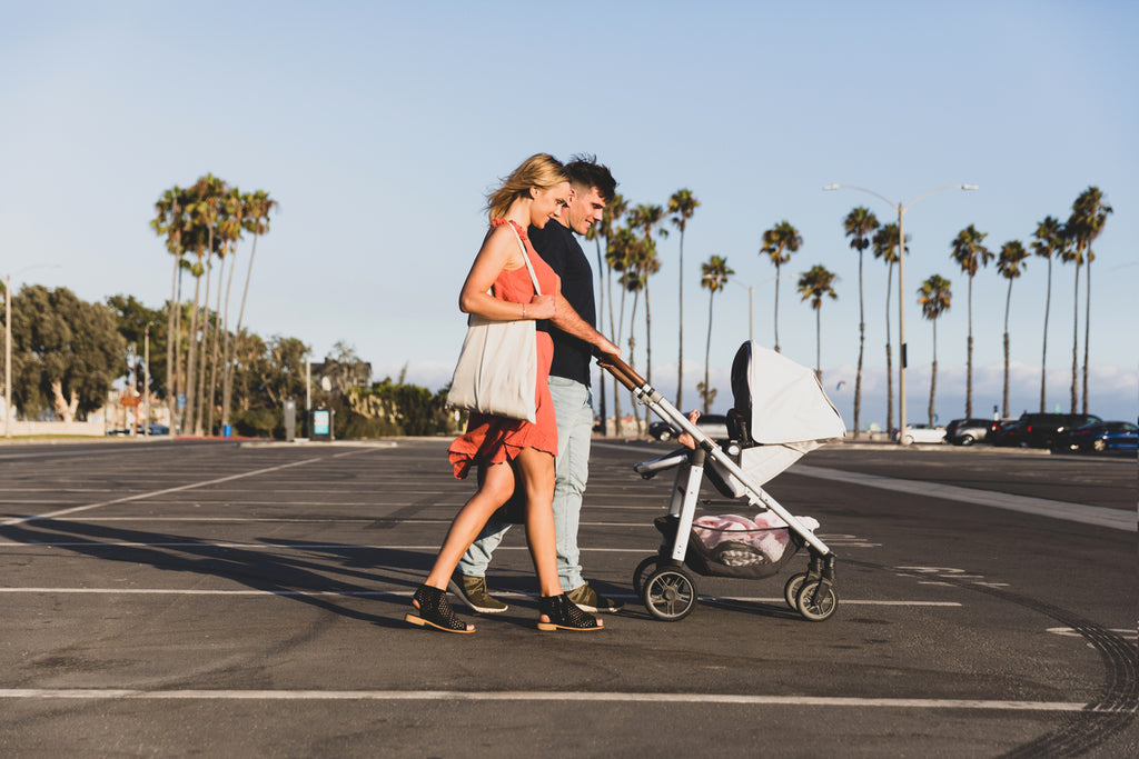 Parents pushing baby must-haves stroller in California
